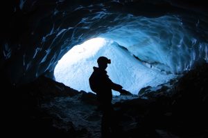 A lonely male hiking in the mountains in a cave